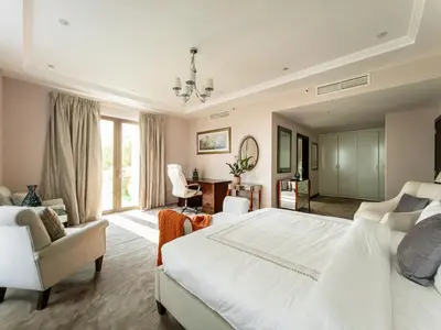 a large bedroom with a large white bed and chairs at Penthouse four bedroom with two large chillout terraces in Dubai