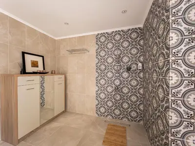 a bathroom with a shower with a tile wall at Penthouse four bedroom with two large chillout terraces in Dubai