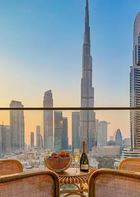 a table with a bowl of fruit and wine glasses at Stunning Burj Khalifa View! Steps to Dubai Mall in Dubai