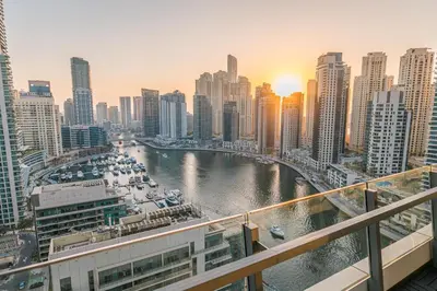 a view of a river in a city with tall buildings at Dubai Marina Skyline with Sunset and Sunrise View in Dubai