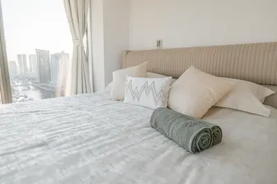 a bedroom with a large bed with a large window at Dubai Marina Skyline with Sunset and Sunrise View in Dubai