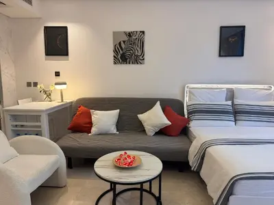a living room with a couch and a bed at The Sterling 4 sleep with AC parking and pool in Dubai