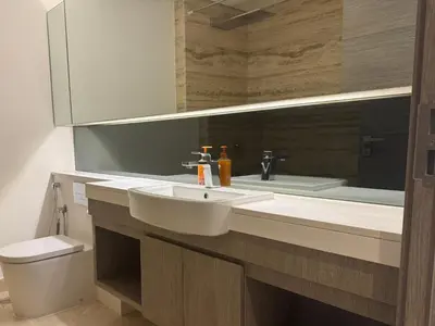 a bathroom with a sink and a toilet and a mirror at The Sterling 4 sleep with AC parking and pool in Dubai