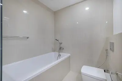 a white bathroom with a tub and a toilet at Sanctuary Stays - Premium 1BR - Burj Khalifa Views - Near Dubai Mall in Dubai