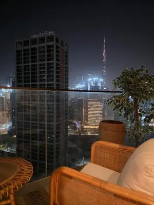 a balcony with a view of a city at night at Medina Studio Burj Khalifa View in Dubai