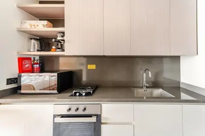 a kitchen with white cabinets and a sink at Medina Studio Burj Khalifa View in Dubai
