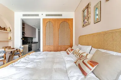 a large white bed in a room with a kitchen at Medina Studio Burj Khalifa View in Dubai