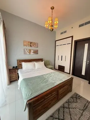 a bedroom with a large bed and a chandelier at Peaceful Cozy 1 BHK Pool Garden View Liwan Dubai Land in Dubai