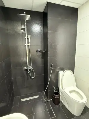 a bathroom with a toilet and a shower at Peaceful Cozy 1 BHK Pool Garden View Liwan Dubai Land in Dubai
