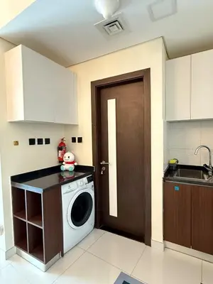a kitchen with a washing machine and a door at Peaceful Cozy 1 BHK Pool Garden View Liwan Dubai Land in Dubai