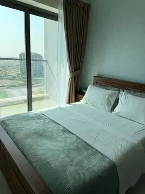a bed in a bedroom with a large window at Peaceful Cozy 1 BHK Pool Garden View Liwan Dubai Land in Dubai