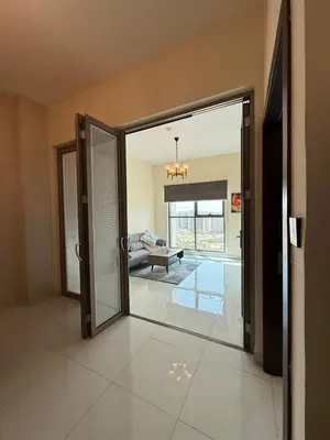 an open glass door in a room with a living room at Peaceful Cozy 1 BHK Pool Garden View Liwan Dubai Land in Dubai