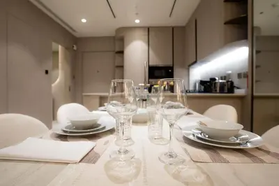 a table with wine glasses and plates on it at Designer 1BR Apt with Modern and Airy Layout in Dubai