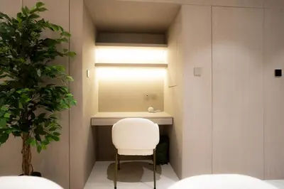 a bathroom with a white chair and a mirror at Designer 1BR Apt with Modern and Airy Layout in Dubai