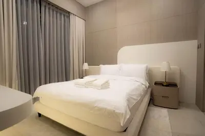 a bedroom with a bed with white sheets and pillows at Designer 1BR Apt with Modern and Airy Layout in Dubai