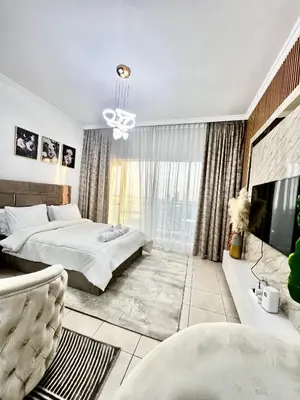 a bedroom with a bed and a large window at Spacious Modern Studio In downtown in Dubai