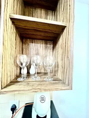 a shelf with three wine glasses on it at Spacious Modern Studio In downtown in Dubai