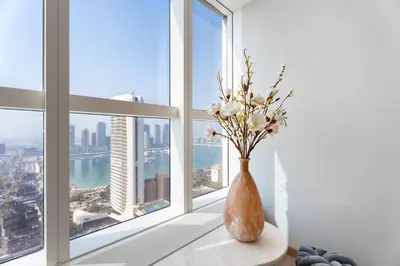 a vase with flowers sitting on a window sill at Luxury Renovated 1BR w Full Sea View in Dubai