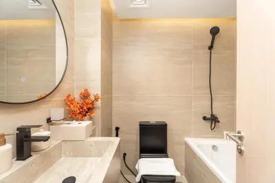 a bathroom with a toilet and a sink and a mirror at Luxury Renovated 1BR w Full Sea View in Dubai
