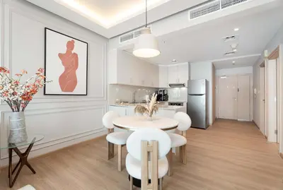a kitchen and dining room with a table and chairs at Luxury Renovated 1BR w Full Sea View in Dubai