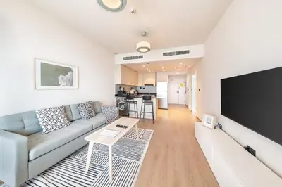 a living room with a couch and a flat screen tv at harborfront elegance dubai in Dubai