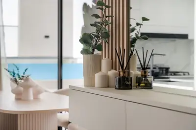 a white kitchen with plants in vases on a counter at VayK - Modern 2BD Retreat with Private Pool in JVC in Dubai