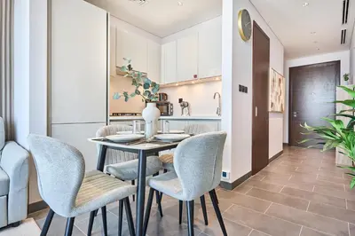 a dining room with a table and chairs at STAY BY LATINEM Luxury 1BR Holiday Home CB 3107 Near Burj Khalifa in Dubai