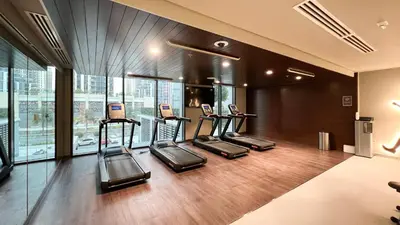 a gym with several treadmills in a building at Luxury 2BR 34th Floor Burj Khalifa Sea Creek View in Dubai