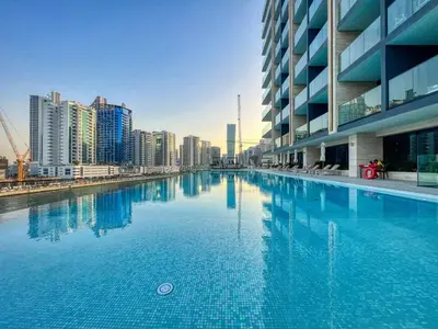 a large swimming pool in the middle of a city at GuestReady - Balcony with Jacuzzi | Canal View in Dubai
