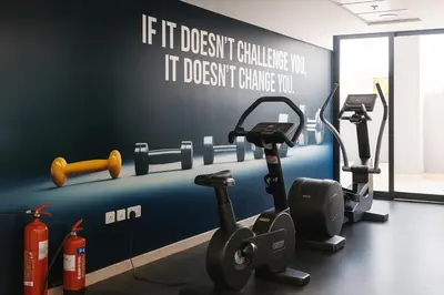 a gym with gym equipment on the wall at Work & Relax Above the City- JVC Perfect Stay in Dubai
