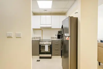 a kitchen with a stainless steel refrigerator and a stove at Work & Relax Above the City- JVC Perfect Stay in Dubai