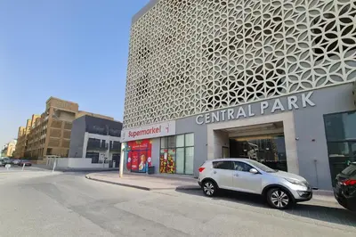 a white car parked in front of a central park building at Work & Relax Above the City- JVC Perfect Stay in Dubai