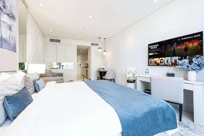 a bedroom with a large bed and a living room at Stunning Studio facing Burj Khalifa in Dubai