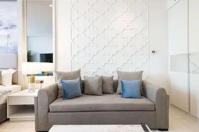 a living room with a couch with blue pillows at Stunning Studio facing Burj Khalifa in Dubai