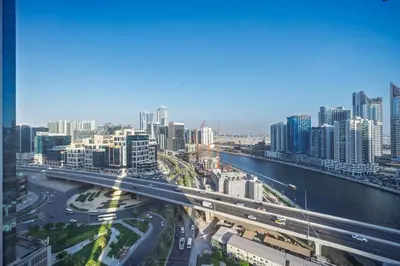 a city with a bridge over a river and buildings at Cozy Waterfront Studio Pool, Gym, Parking in Dubai