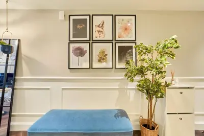 a room with a blue ottoman and pictures on the wall at FAM Living Contemporary 1BR Apartment Urban Oasis in Dubai