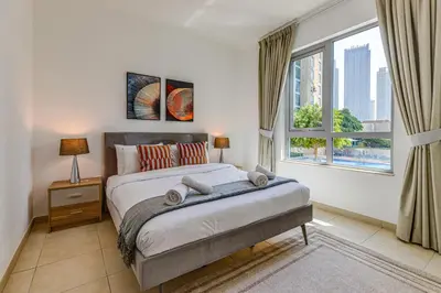 a bedroom with a bed and a large window at Residences 1 Tower 5 E2 - 2BR Apartment - Allsopp & Allsopp in Dubai