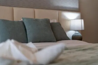 a bedroom with a bed with pillows and a lamp at TRPS - Imperial Avenue, Downtown - Burj Khalifa View, Brand New, Amazing Facilities in Dubai