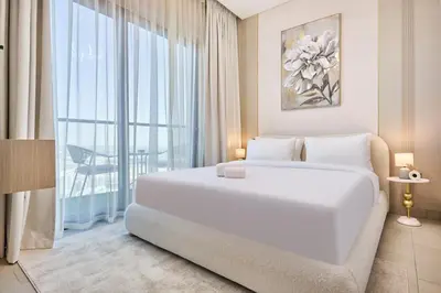 a bedroom with a white bed and a large window at STAY BY LATINEM Luxury 1BR Holiday Home W 2809 Near Burj Khalifa in Dubai