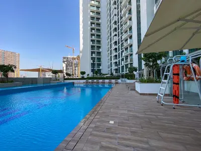 a swimming pool with a ladder next to a building at Fawad Azizi Residence, Al Jaddaf- 1BR - Allsopp & Allsopp in Dubai