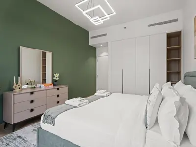 a bedroom with a large white bed and a dresser at Coastal Haven 1BDR in La Cote B4-12 in Dubai