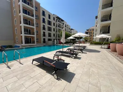 a row of lounge chairs next to a swimming pool at Coastal Haven 1BDR in La Cote B4-12 in Dubai