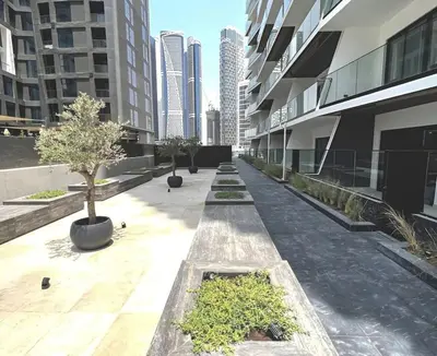 a courtyard in a building with trees and buildings at Bright Studio in Binghatti Canal in Dubai