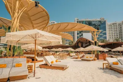 a beach with chairs and umbrellas on the sand at FIVE Palm Jumeirah 3BR plus Luxury Lifestyle Residence in Dubai