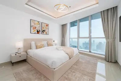 a white bedroom with a bed and a large window at High-Floor Upgraded 3-Bed Marina Apartment in Dubai