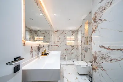 a bathroom with a white sink and a toilet at High-Floor Upgraded 3-Bed Marina Apartment in Dubai