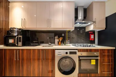 a kitchen with a washing machine and a stove at Stylish and Spacious Downtown Studio in Dubai