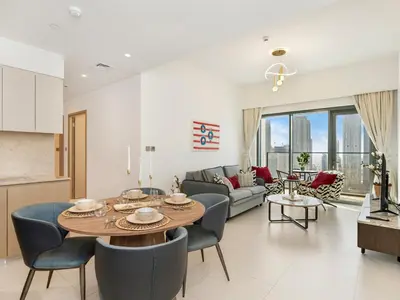 a dining room and living room with a table and chairs at Iconic Burj and Fountain View 2BR Downtown in Dubai
