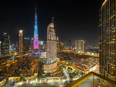 a city skyline at night with a tall building at Iconic Burj and Fountain View 2BR Downtown in Dubai
