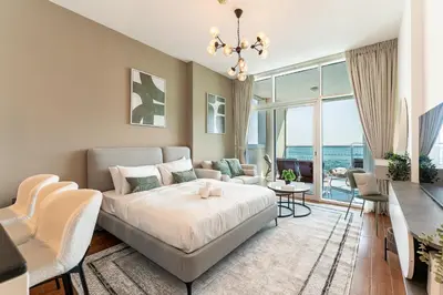 a bedroom with a bed and a living room at HAVN - Studio in Al Jawhara, JVT in Dubai